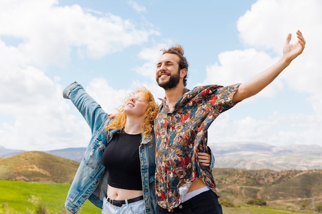 Hombre y mujer abren los brazos a la libertad.