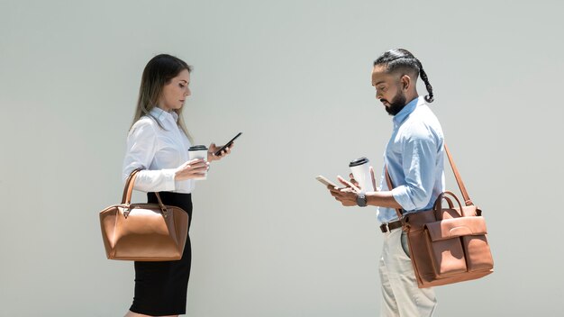 Hombre y mujer adictos a sus teléfonos incluso al aire libre