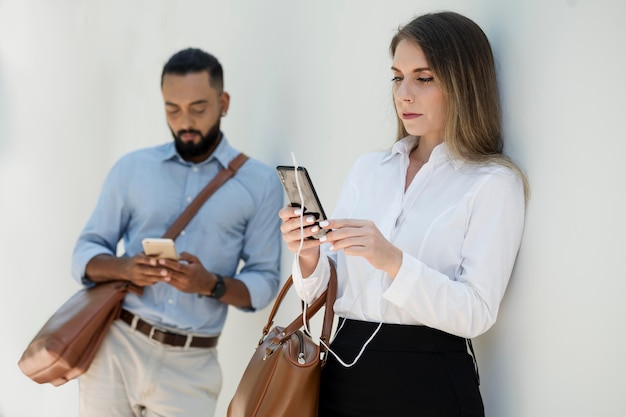 Foto gratuita hombre y mujer adictos a sus teléfonos incluso al aire libre