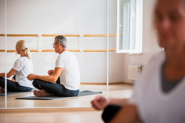 Hombre y mujer adultos meditando yoga