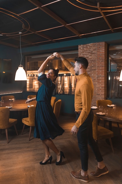 Hombre mujer alegre girando en el restaurante