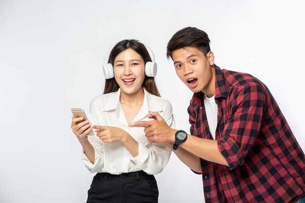 El hombre y la mujer aman escuchar música en sus teléfonos inteligentes
