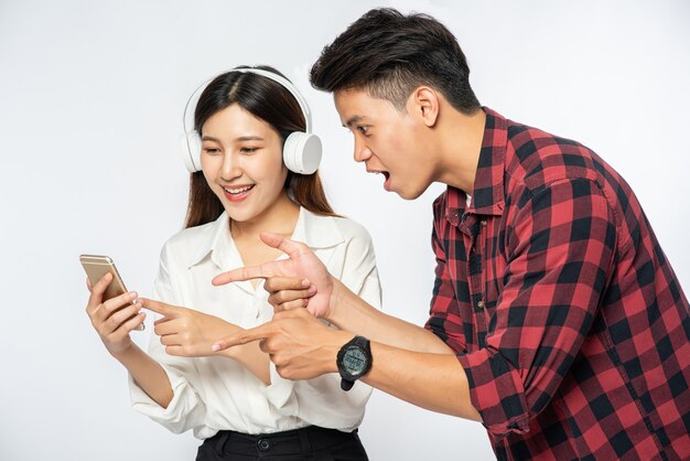 El hombre y la mujer aman escuchar música en sus teléfonos inteligentes