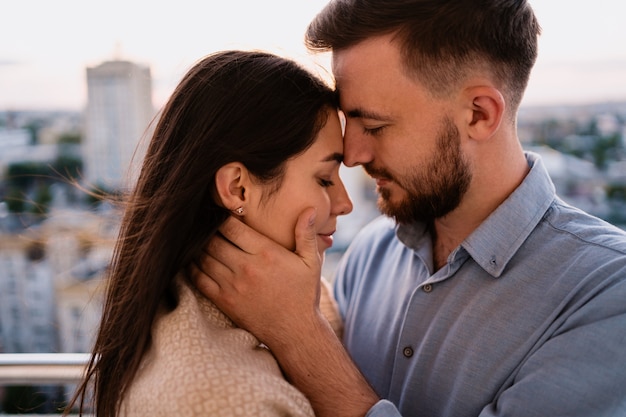 Hombre y mujer en el balcón al atardecer en la ciudad