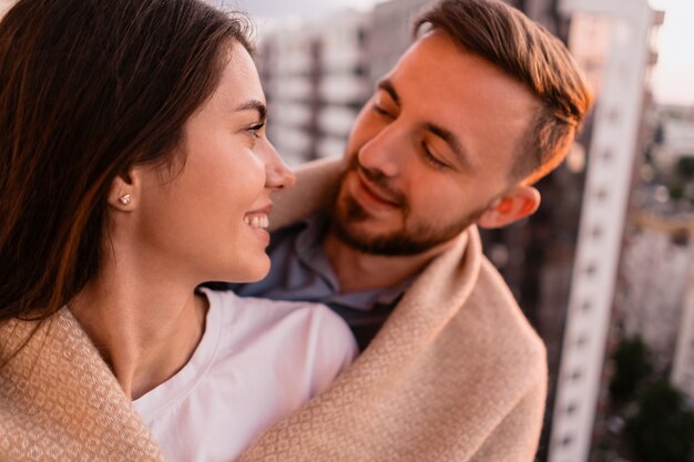 Hombre y mujer en el balcón al atardecer en la ciudad