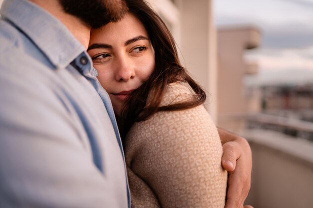 Hombre y mujer en el balcón al atardecer en la ciudad