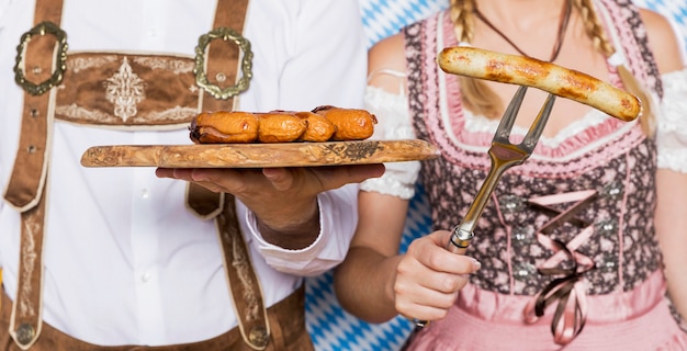 Hombre y mujer bávara con aperitivos oktoberfest