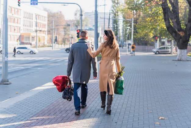 Hombre y mujer con bolsas de calle.