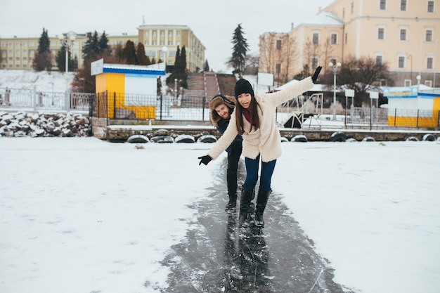 Hombre y mujer cabalgando sobre el hielo en un lago congelado