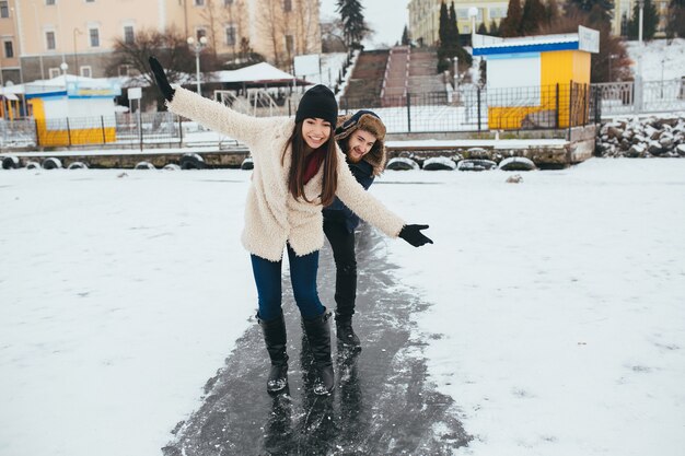 Hombre y mujer cabalgando sobre el hielo en un lago congelado