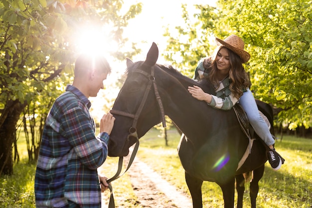 Hombre y mujer, con, caballo, tiro medio