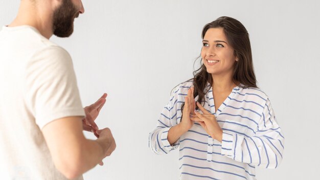 Hombre y mujer casual que se comunican a través del lenguaje de señas