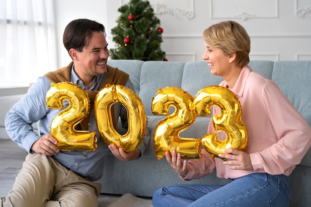 Hombre y mujer celebrando la víspera de año nuevo en casa juntos