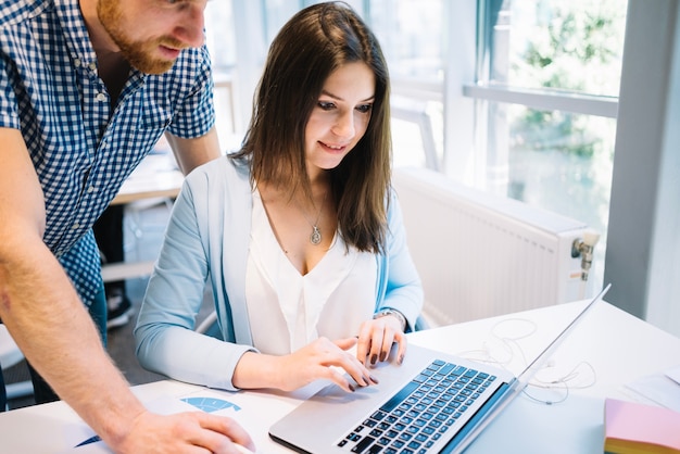 Hombre y mujer colaborando en la computadora portátil