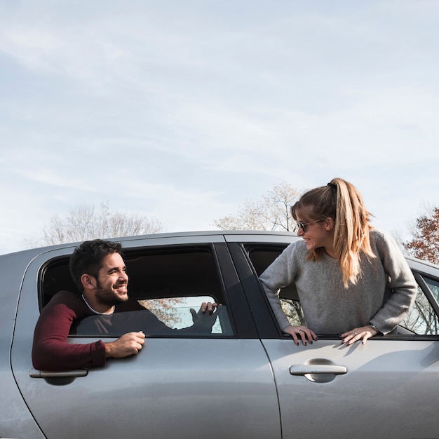 Foto gratuita hombre y mujer colgando de la ventana del coche