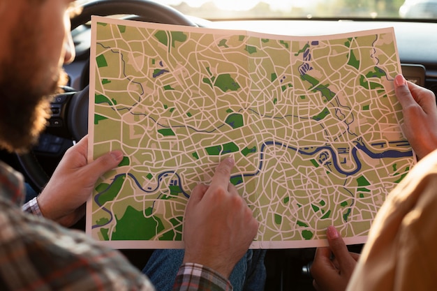 Foto gratuita hombre y mujer comprobando un mapa en el coche