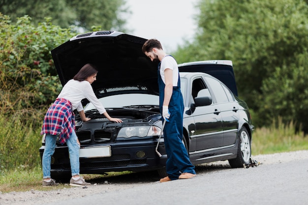 Hombre y mujer comprobando el motor del coche