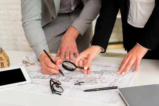 Hombre y mujer comprobando un plan de construcción