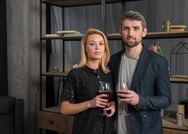 Hombre y mujer con copas de vino en la habitación.