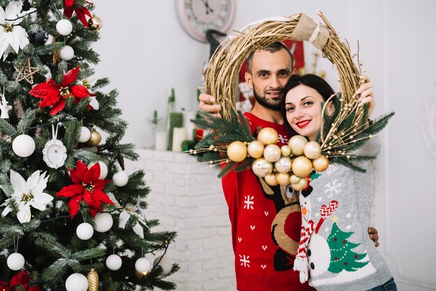 Hombre y mujer con corona de navidad