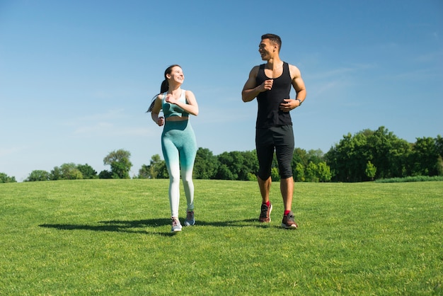 Hombre y mujer corriendo al aire libre en un parque