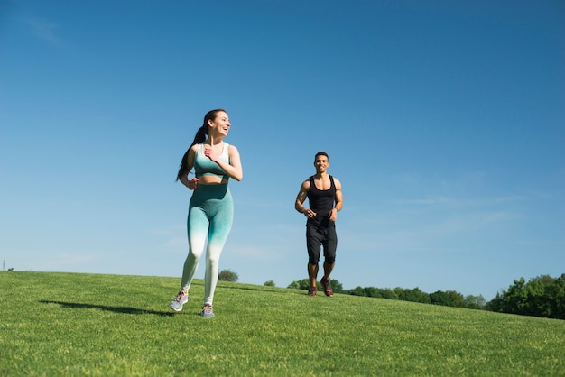 Hombre y mujer corriendo al aire libre en un parque