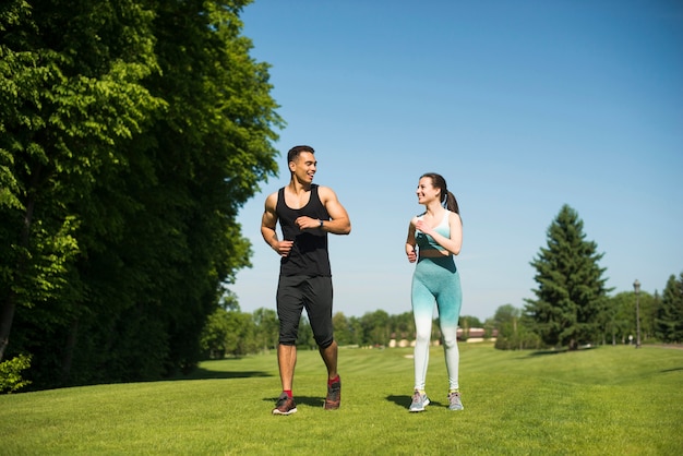 Foto gratuita hombre y mujer corriendo al aire libre en un parque