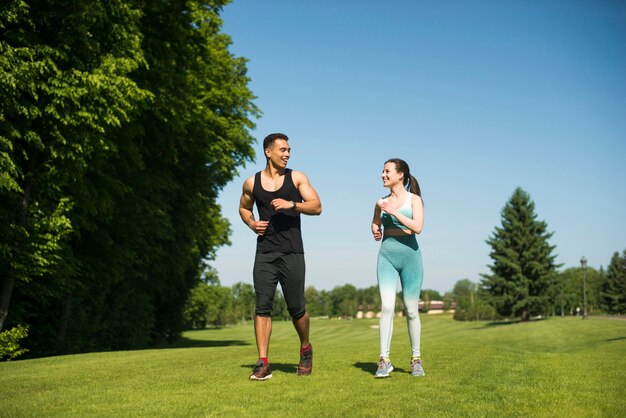Hombre y mujer corriendo al aire libre en un parque