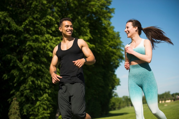 Hombre y mujer corriendo al aire libre en un parque