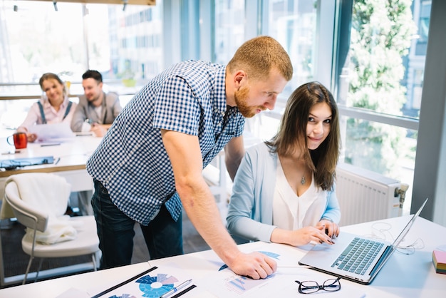 Foto gratuita hombre y mujer coworking en la computadora portátil