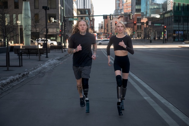 Hombre y mujer con discapacidad en las piernas corriendo en la ciudad