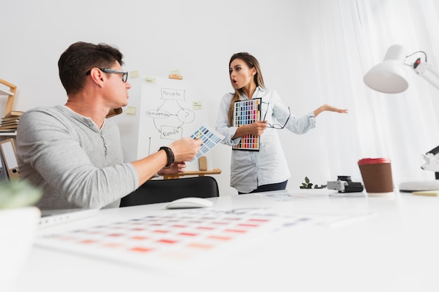 Hombre y mujer discutiendo sobre los resultados de la compañía