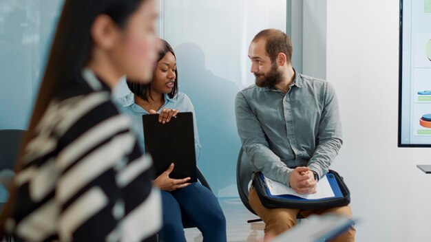 Hombre y mujer discutiendo la solicitud de contratación en la cola, esperando para unirse a la reunión de entrevista de trabajo. Personas nerviosas con papeles de empleo y cv conversando en el vestíbulo de la oficina, selección de trabajo.