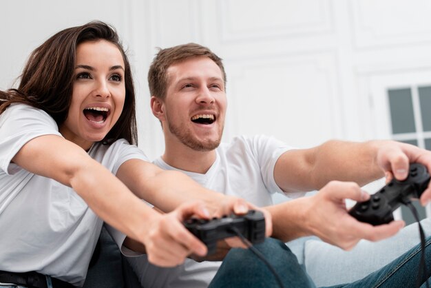 Hombre y mujer divirtiéndose mientras juegan con controladores