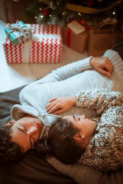 Hombre y mujer durmiendo en cajas presentes.