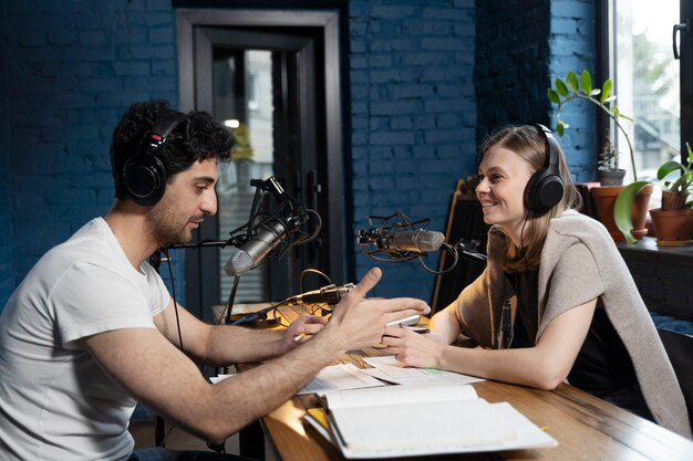 Hombre y mujer ejecutando un podcast juntos en el estudio