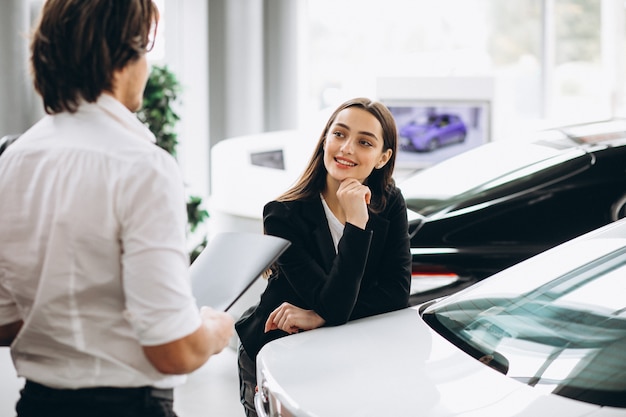 Hombre y mujer eligiendo un automóvil en una sala de exposición de automóviles