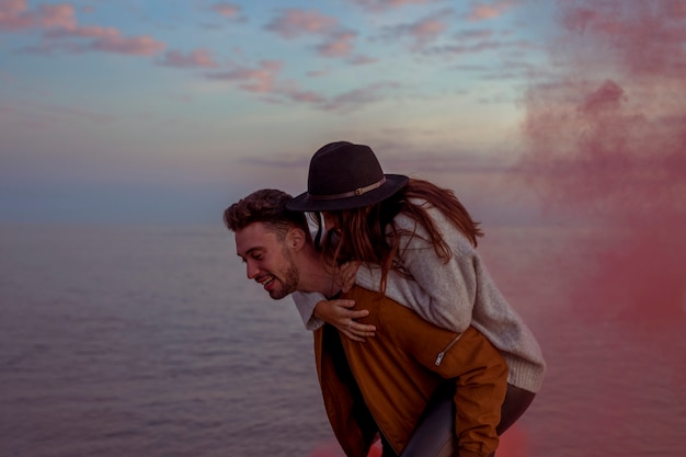 Foto gratuita hombre con mujer en la espalda en la orilla del mar