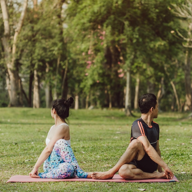 Hombre y mujer estirando en el parque