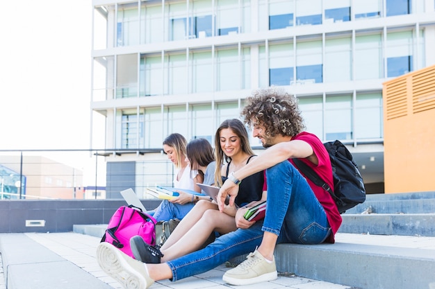 Hombre y mujer estudiando cerca de amigos