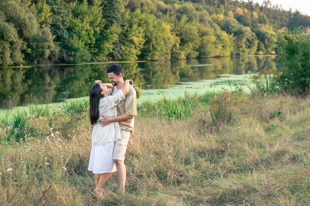Foto gratuita hombre y mujer felices en la naturaleza junto al río disfrutando unos de otros