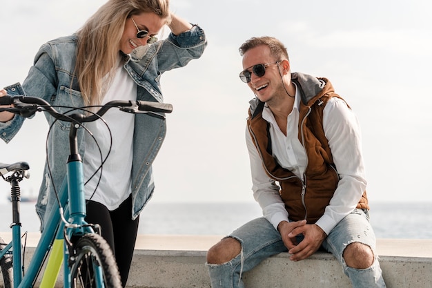 Foto gratuita hombre y mujer hablando junto a una bicicleta