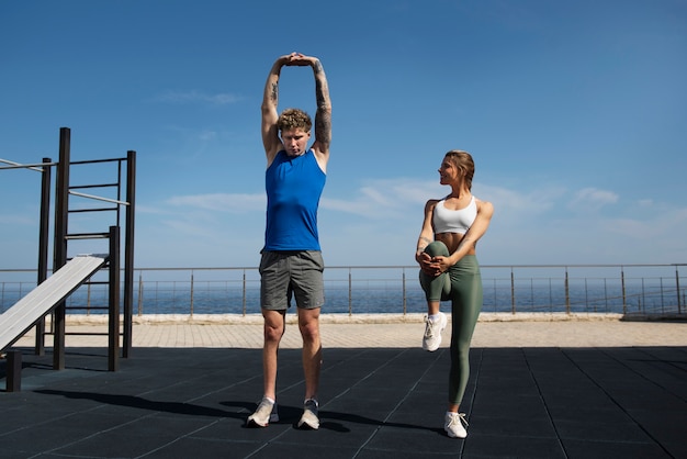 Foto gratuita hombre y mujer haciendo ejercicio juntos al aire libre