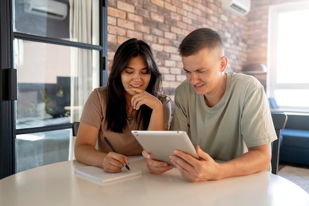 Hombre y mujer haciendo lista de compras con tableta