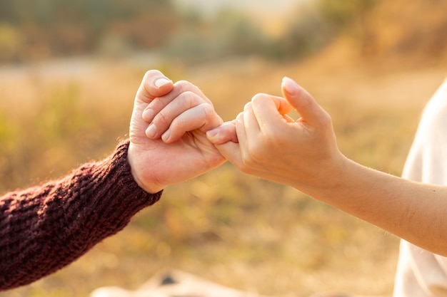 Hombre y mujer haciendo una promesa de meñique