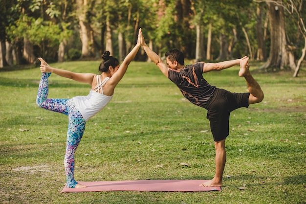 Foto gratuita hombre y mujer haciendo yoga en la naturaleza