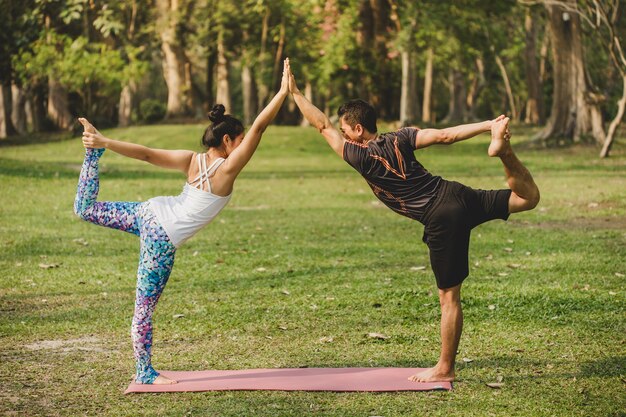 Hombre y mujer haciendo yoga en la naturaleza