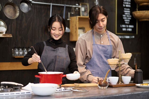 Hombre y mujer japoneses cocinando en un restaurante.
