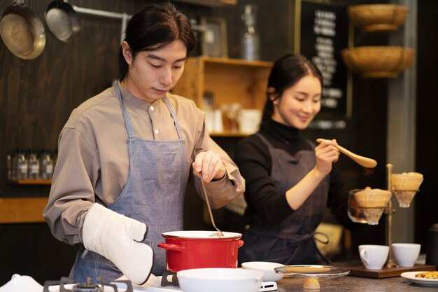 Hombre y mujer japoneses cocinando en un restaurante.