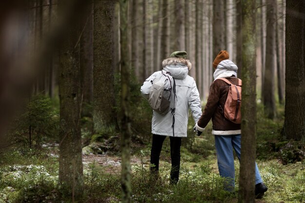 Hombre y mujer joven en un bosque juntos durante un viaje por carretera de invierno